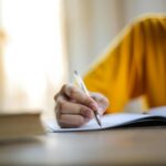 person writing on laptop