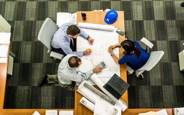 A diverse group of office workers looking confused at a screen displaying a meme.