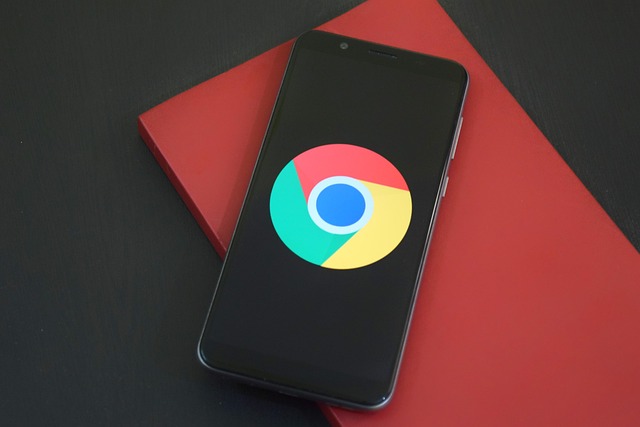 Google Android plush toy next to a laptop displaying the Android logo