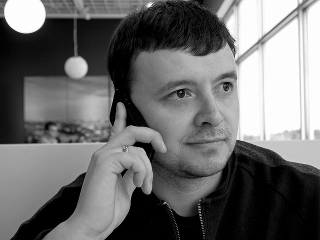 A person using a smartphone to control smart home devices like lights and thermostat