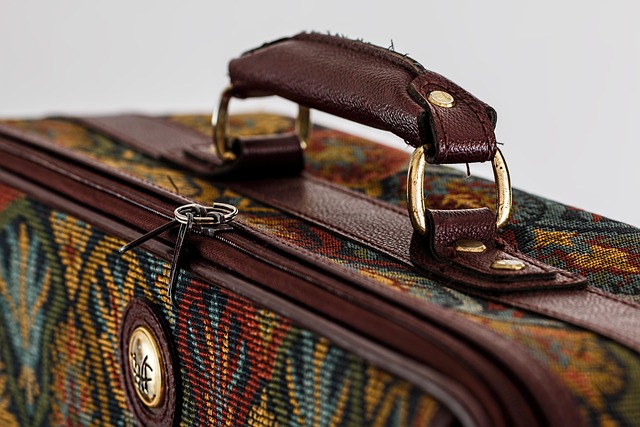 Woman packing a suitcase with various travel gadgets
